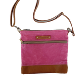 A pink and waxed canvas Ellis River Crossbody Bag by Tradevia on a white surface.