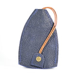 A dark blue durable cowhide Rogue Leather Key Protective Case by Tradevia with a brown leather strap loop and a brass button closure, standing upright on a white background.