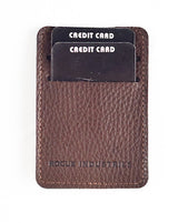 The Rogue Money Clip by Tradevia, made from genuine top-grain brown leather, easily fits in your front pocket. It securely holds two black credit cards and conveniently functions as a money clip wallet.