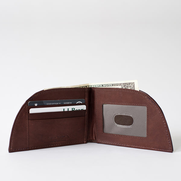 A brown leather Tradevia NON-RFID Made in Maine minimalist wallet with a credit card in it.