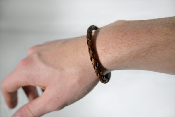 A person's hand with a Tradevia Rogue Braided Moose Leather Bracelet on it.