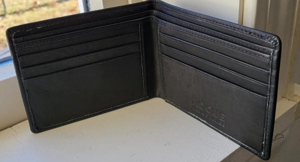 A black, Tradevia R11 top-grain leather wallet sitting on a window sill.