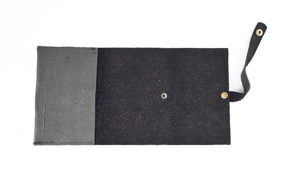 Introducing the LEATHER TECH ORGANIZERS - BLACK BISON by Tradevia: This sophisticated wallet is crafted from luxurious black bison leather and features an open design that reveals its organized interior. Equipped with a strap and snap button closure on the right side, it's perfect for neatly storing essentials such as cards and cord holders.