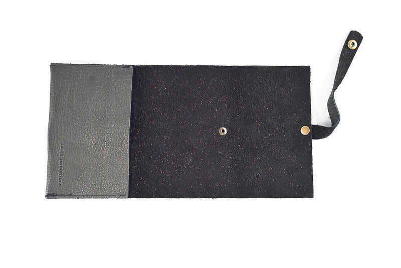 Introducing the LEATHER TECH ORGANIZERS - BLACK BISON by Tradevia: This sophisticated wallet is crafted from luxurious black bison leather and features an open design that reveals its organized interior. Equipped with a strap and snap button closure on the right side, it's perfect for neatly storing essentials such as cards and cord holders.