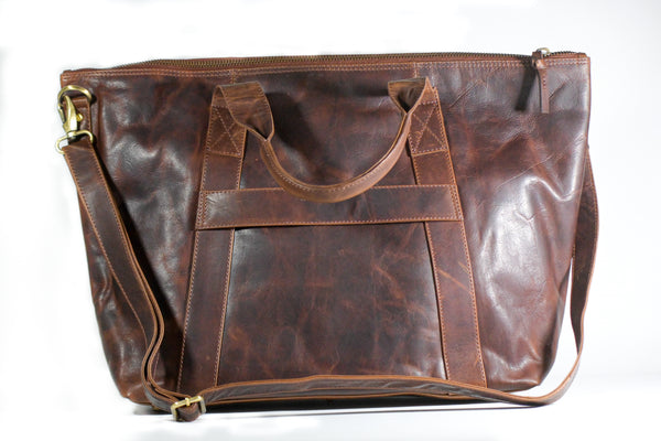 A brown full-grain leather Rockport weekend tote bag by Tradevia on a white background.