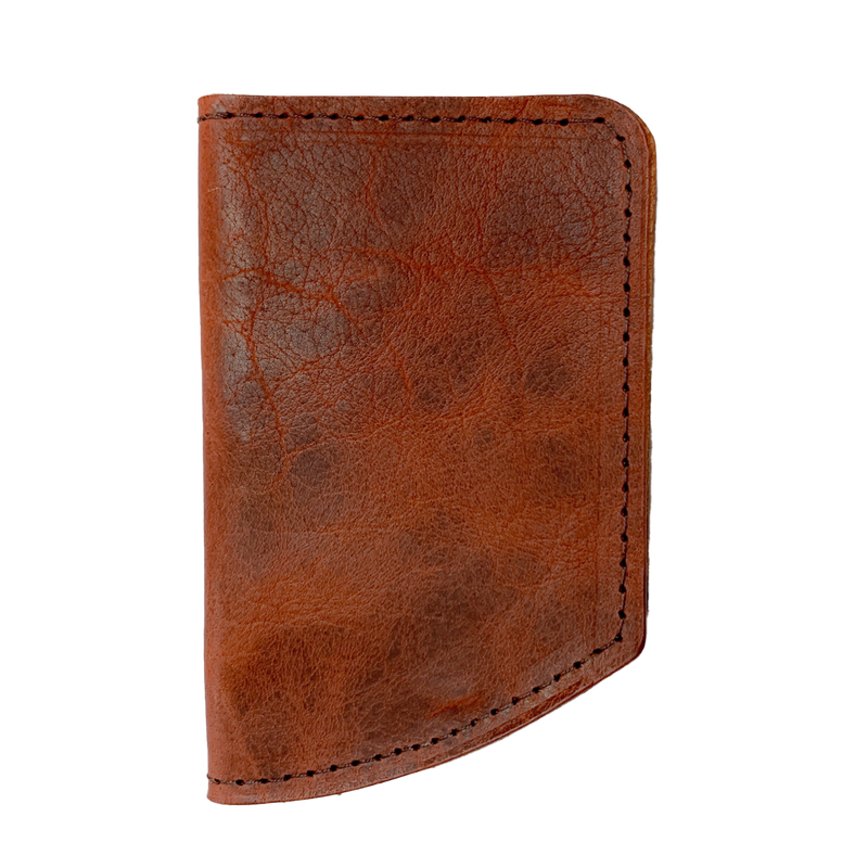 A slim brown leather Tradevia Minimalist Wallet on a black background.