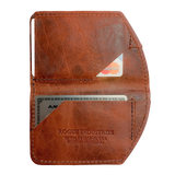 A brown, slim leather Tradevia Minimalist Wallet with a credit card in it.