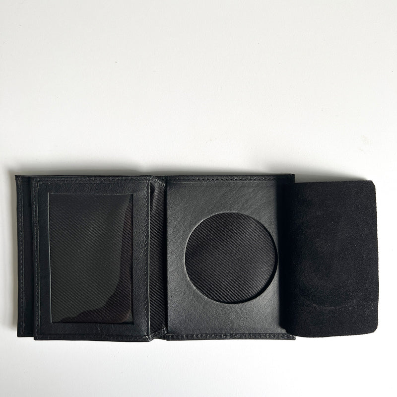 A black Tradevia Leather Badge Holder Wallet with a black coin inside, designed as a badge holder for first responders.