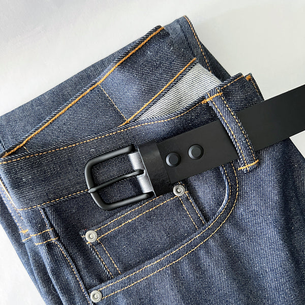 A pair of jeans with a handmade, Tradevia Baxter Leather Belt - 1.5" Wide.