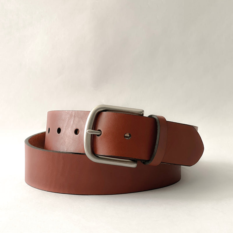 A handmade Brown Cowhide Leather Baxter Belt - 1.5" Wide by Tradevia on a white background.