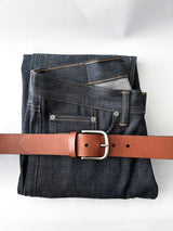 A pair of jeans with a Tradevia Baxter Leather Belt - 1.5" Wide.