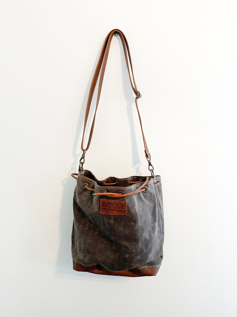 A Tradevia Kennebunkport Bucket Bag on a wall.