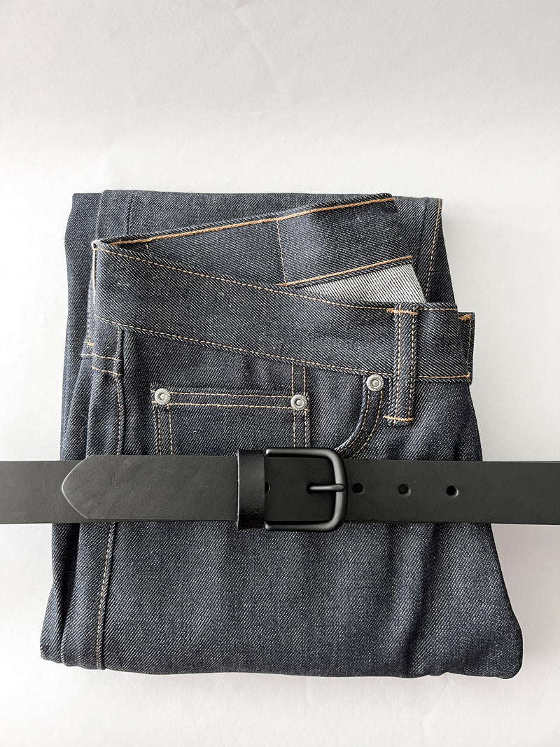 A pair of jeans with a Tradevia Chamberlain Leather Belt - 1.25" Wide.