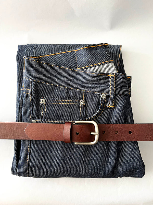 A pair of jeans with a Tradevia Chamberlain Leather Belt - 1.25" Wide.