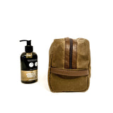 A durable, brown Tradevia Waxed Canvas Dopp kit with a bottle of soap next to it, made in the USA.