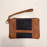 A tan and blue Eastport Clutch waxed canvas zippered pouch with a leather strap from Tradevia.