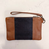 A Tradevia Eastport Clutch with a black stripe.