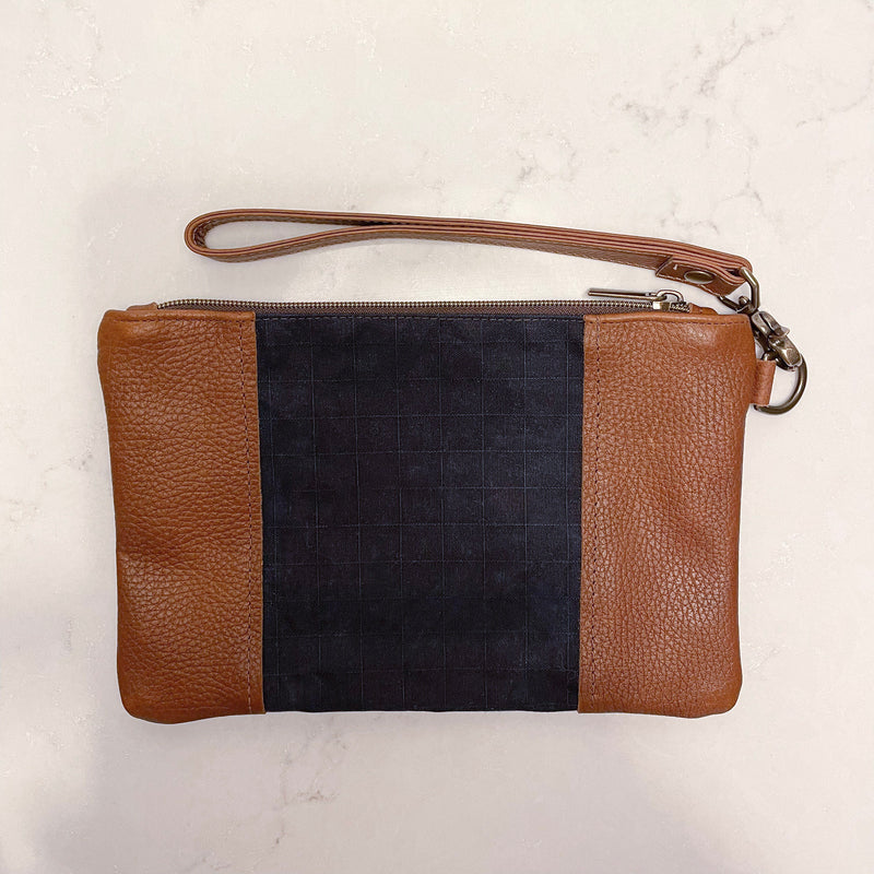 A Tradevia Eastport Clutch with a black stripe.