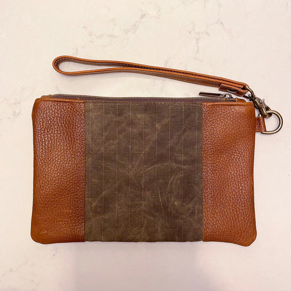 A brown and tan leather Eastport Clutch by Tradevia with a zipper.