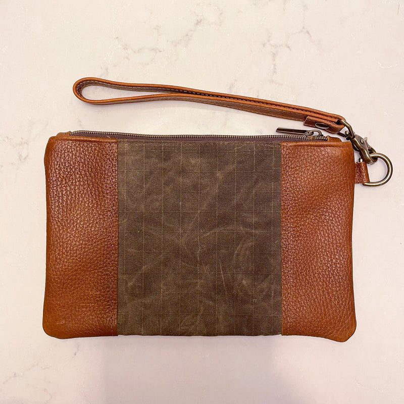 A brown and tan leather Eastport Clutch by Tradevia with a zipper.