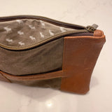 A brown and tan waxed canvas pouch with a deer on it, the Eastport Clutch by Tradevia.