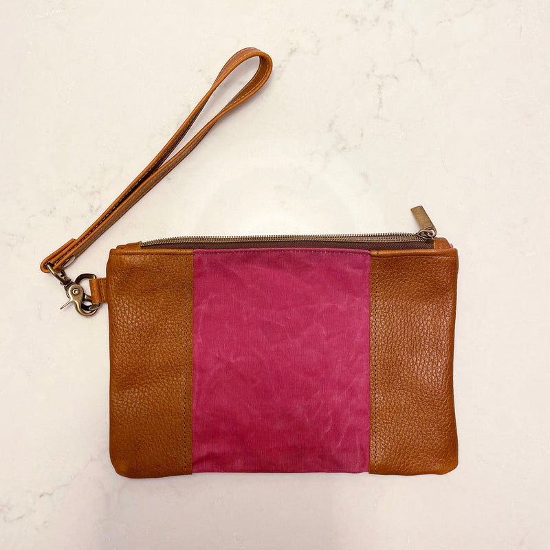 A tan and pink Eastport Clutch by Tradevia with a zipper.