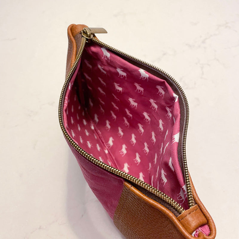 The inside of a pink and tan waxed canvas Eastport Clutch cosmetic bag by Tradevia.