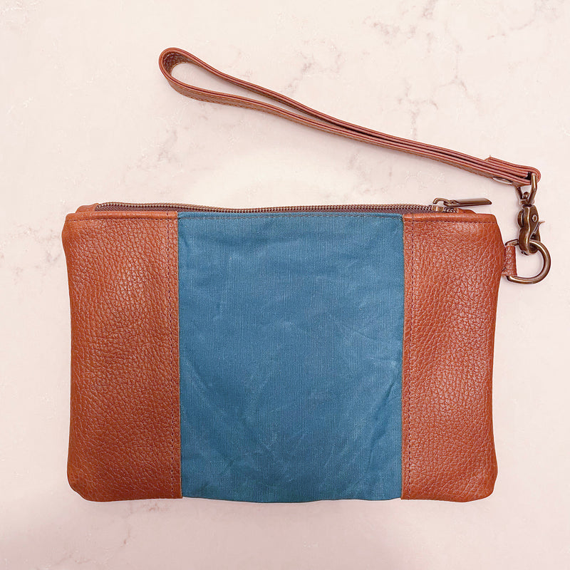 A blue and tan Tradevia Eastport Clutch with a strap.