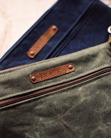 A blue and brown waxed canvas Ellis River Crossbody Bag with a cowhide leather strap by Tradevia.