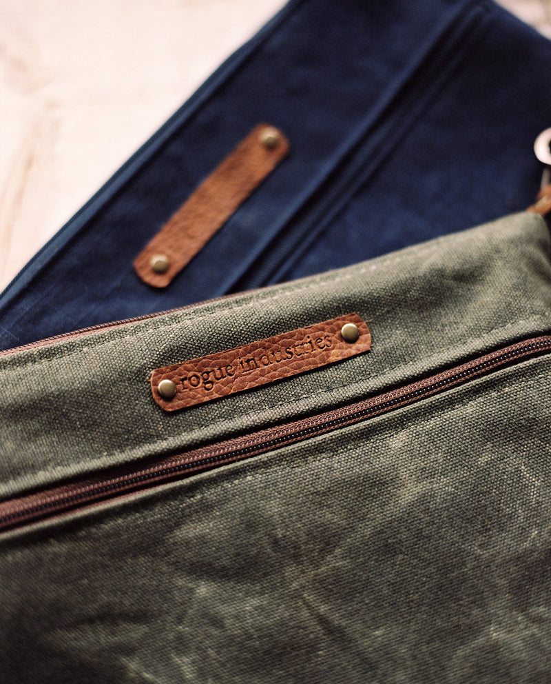 A blue and brown waxed canvas Ellis River Crossbody Bag with a cowhide leather strap by Tradevia.