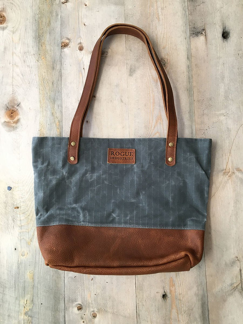 A Saco River Tote Bag by Tradevia on a wood surface.