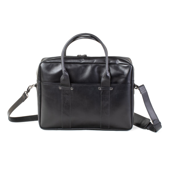 The black Tradevia Katahdin Leather Briefcase with a removable strap is on a white background.