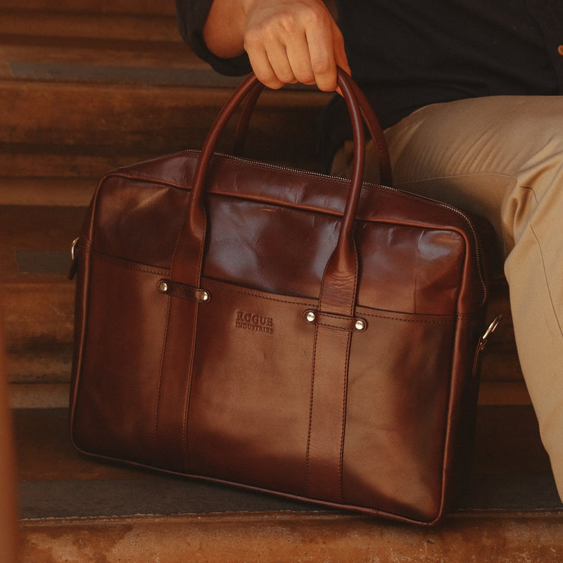 A man holding a brown, Tradevia Katahdin Leather Briefcase.