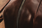A close up of a brown Tradevia Katahdin Leather Briefcase with zippers.