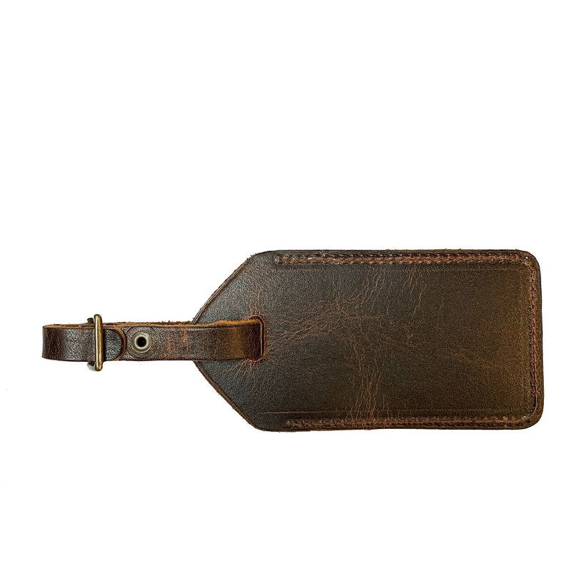 A brown Tradevia cowhide leather luggage tag made in Maine on a white background.