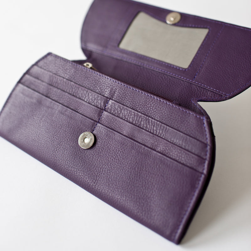 A purple leather RFID Blocking Clutch with a mirror and ostrich print from Tradevia.