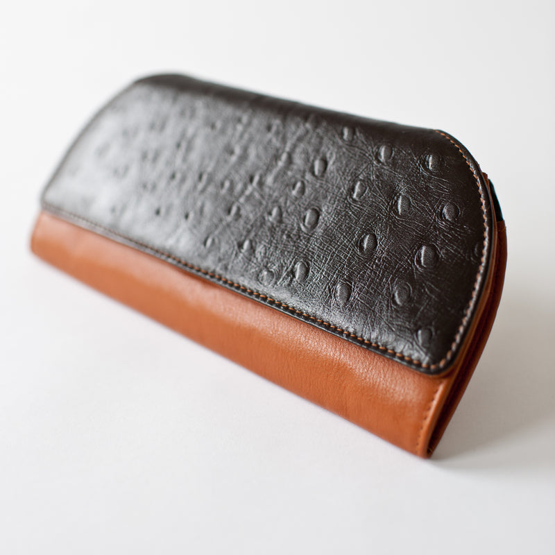 A brown and black Tradevia RFID Blocking Clutch - Ostrich Print.