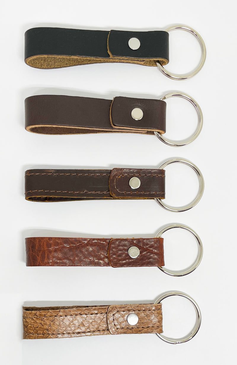 Four durable Tradevia leather key chains in different colors, each with a nickel rivet.