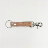 A tan, durable Tradevia leather keychain on a white background.