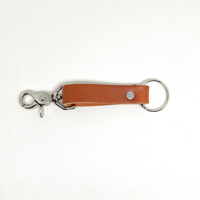 A tan Tradevia Leather Key Chain with a durable metal hook and nickel rivet.