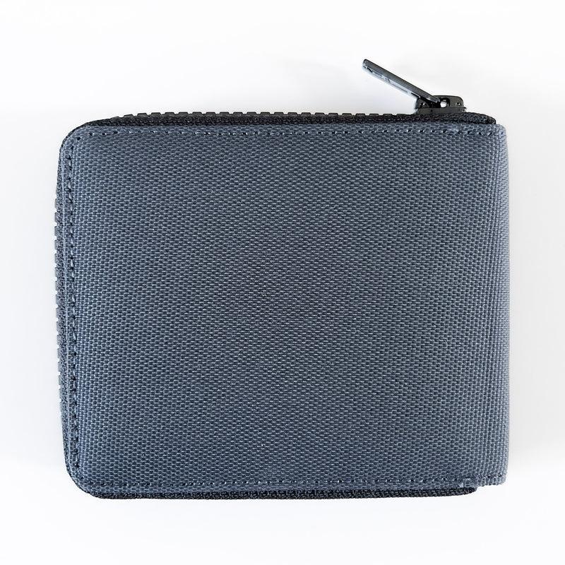 A grey Tradevia RFID blocking Nylon Zip Around Wallet with a YKK zipper on a white surface.
