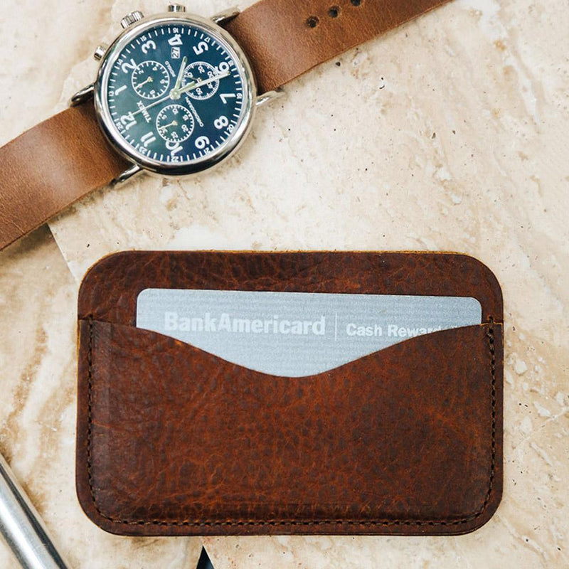 A Maine-crafted leather wallet with a watch and a Tradevia American Bison leather card case.
