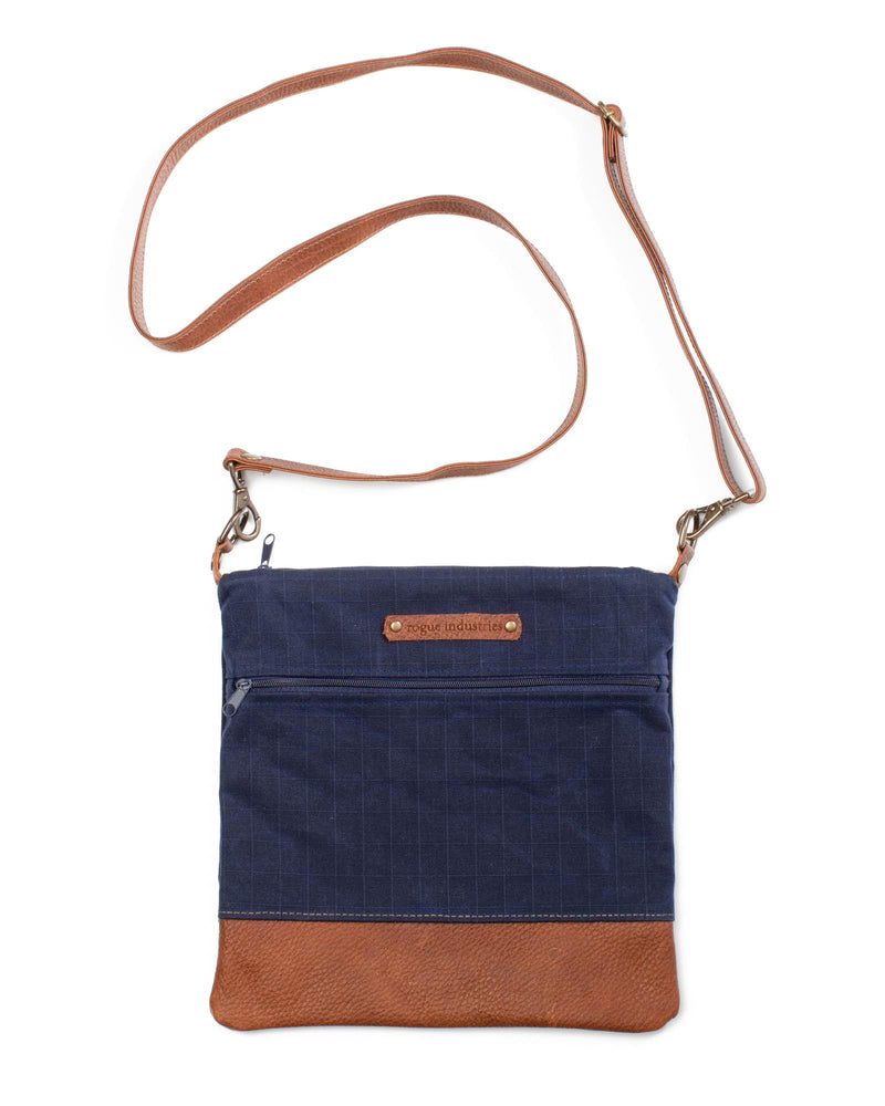 A blue and brown waxed canvas Ellis River crossbody bag by Tradevia.