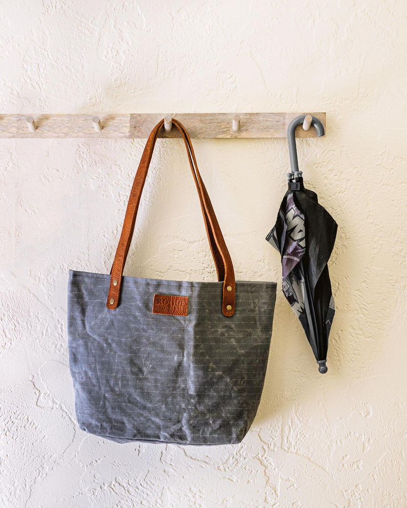 A durable Tradevia Allagash River Tote Bag hanging on a wall.