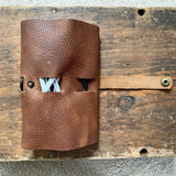 A Tradevia Leather Tech Organizer on a wood surface.