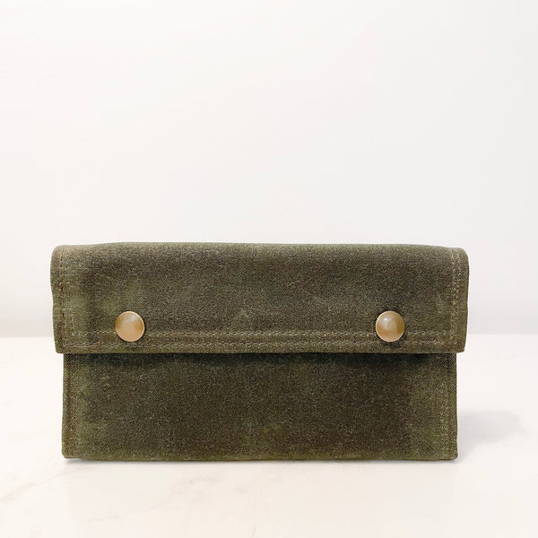 A green Tradevia waxed canvas bag with two buttons.