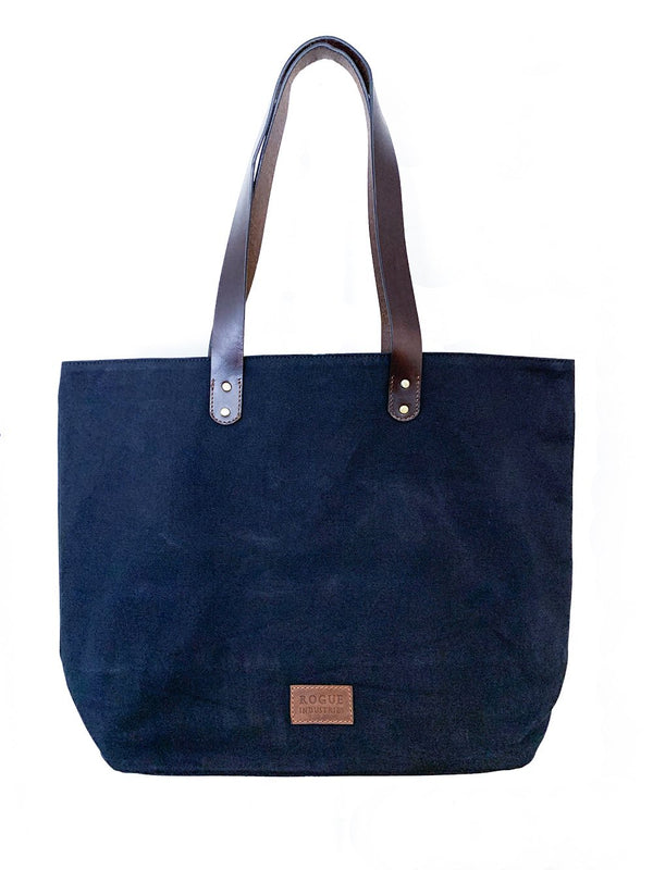 A black Tradevia waxed canvas tote bag with top-grain leather straps.