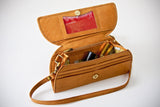 A brown leather RFID Blocking Clutch - Ostrich Print with a red card and a red plastic card inside by Tradevia.